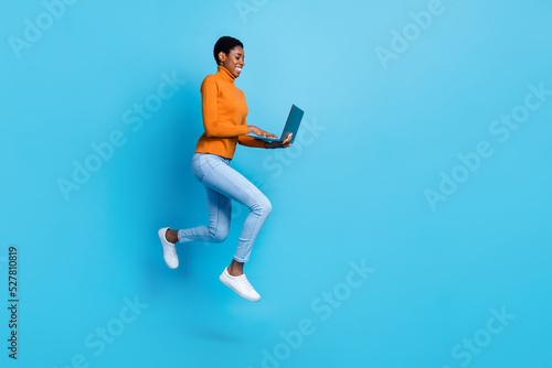 Full size profile side photo of jumping lesbian businesslady surfing in netbook isolated on blue color background