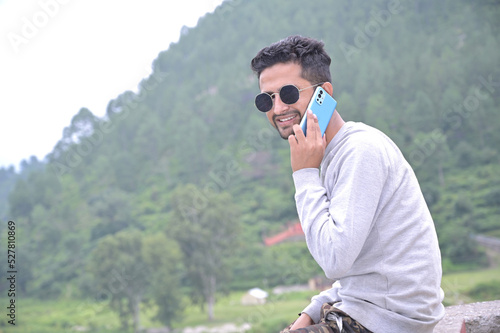 a yong tourist boy sudden captured while communicate by mobile phone in forest.