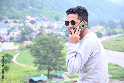 a man talks on the phone around the nature.