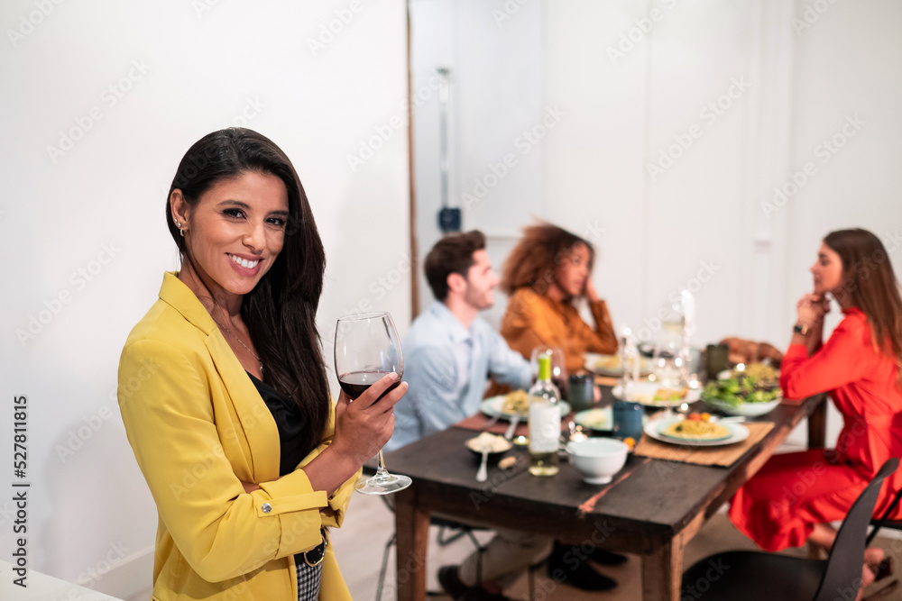 Smiling young woman looking at camera during party with friends Smiling young woman looking at camera during party with friends