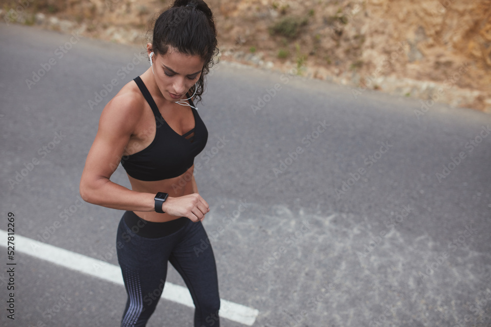 Fit young woman checking her progress on a smartwatch Fit young woman checking her progress on a smartwatch