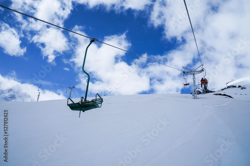 Chiarlift or ski lift in snow mountains in winter day, slopes and sky with clouds