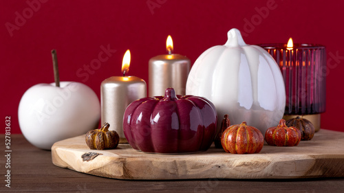 Autumn home decor with ceramic pumpkins, burning candles. Cozy autumn home concept