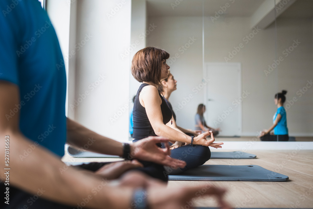 Group of people with instructor practicing yoga in studio Group of people with instructor practicing yoga in studio
