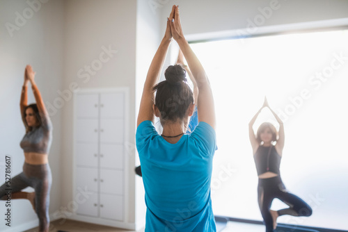 Instructor with group of people practicing yoga asana photo