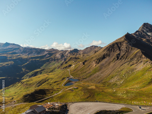 Bird's eye view of serpentine curves at sunny day. Aerial view of scenic route in Austria with name Grossglockner High Alpine Road. Some of hairpin turns of Hochtor Pass.