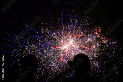 Black silhouette of people on the background of fireworks