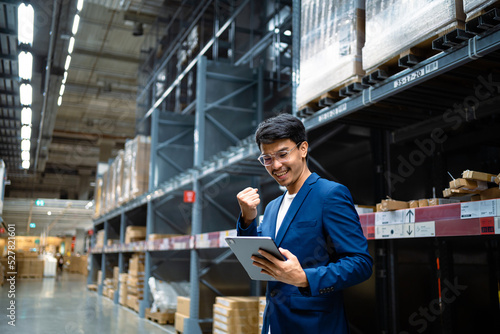 concept of success. An Asian businessman in a large warehouse checks cardboard boxes in a logistics distribution center. Logistics and export business Factory warehouse. business Industrial. warehouse