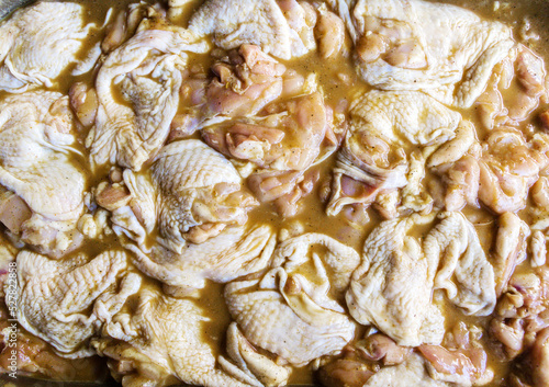 Many raw piece of fresh chicken meat in marinade ready to cooking barbecue close-up