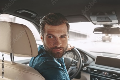 Handsome Caucasian business man parking his automobile