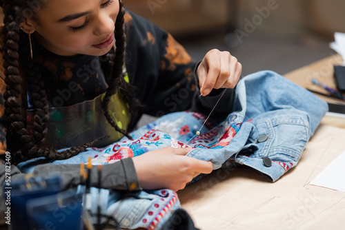 Cuadro en lienzo African american designer decorating denim jacket with embroidery in workshop