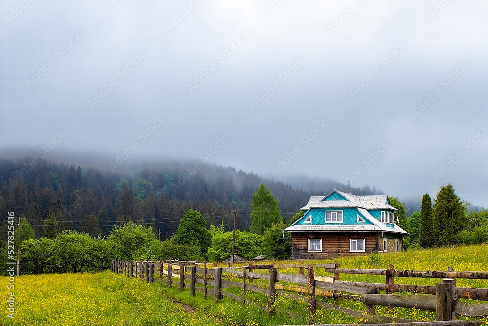 house on the background of cloudy mountains