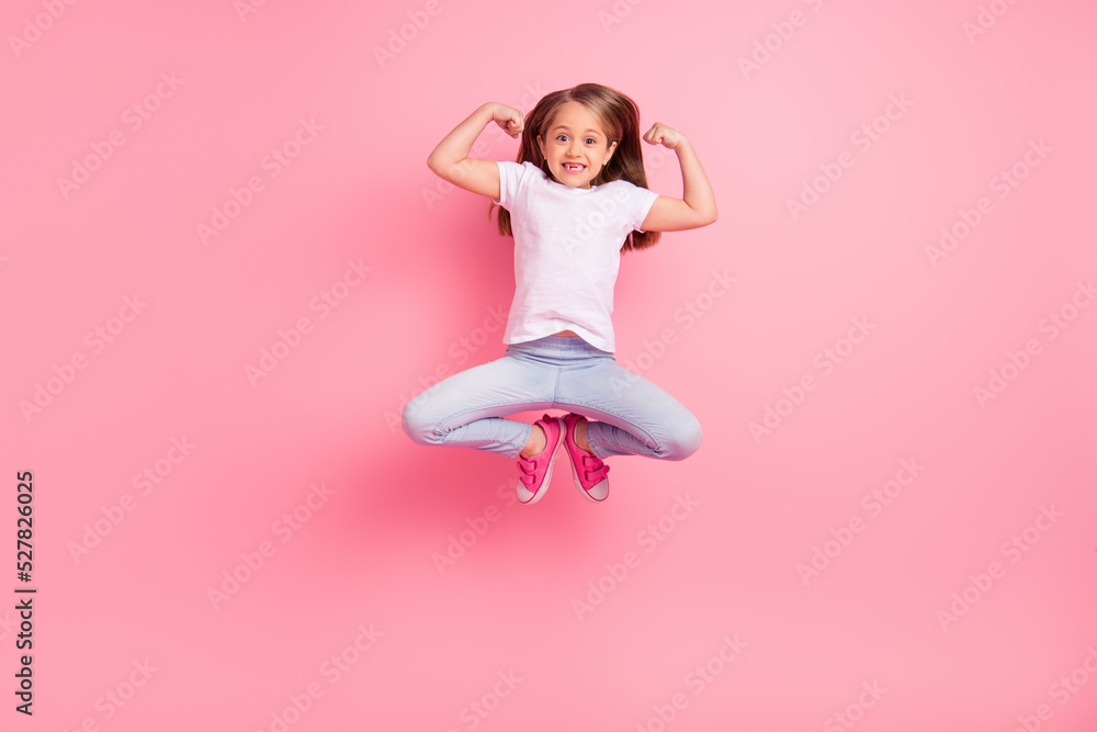 Full length portrait of delighted cheerful kid jump hands showing biceps celebrate success isolated on pink color background Full length portrait of delighted cheerful kid jump hands showing biceps celebrate success isolated on pink color background