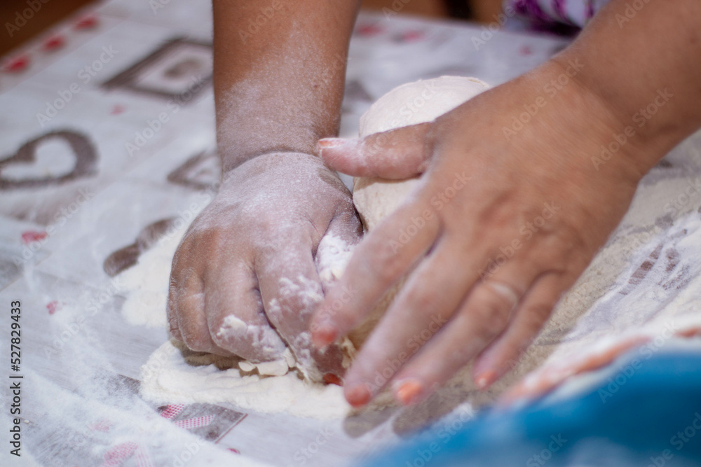a woman kneading natural dough with white flour by hand