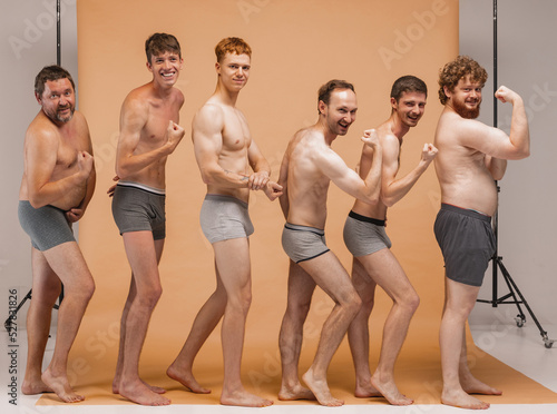 Foto Group of emotional men of different ages having photo shoot at studio