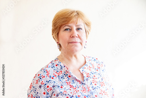 Portrait of 60-year-old woman on white background.