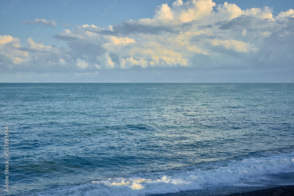 Fototapeta premium Sea shore with pebbles, wet sea pebbles on the beach and quiet sea surf