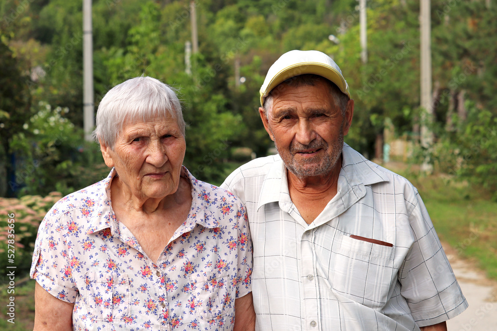 Portrait of elderly couple standing on rural street. Old man and woman together, leisure in park, life in retirement