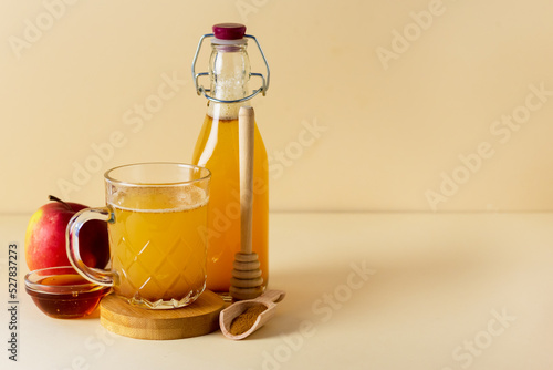 Glass Mug of Fresh Organic Apple Cider with Honey and Cinnamon Yellow Background Horizontal Copy Space