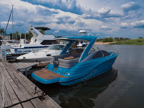 Boats moored to a pier in a yacht marina. Summer vacations and tourism