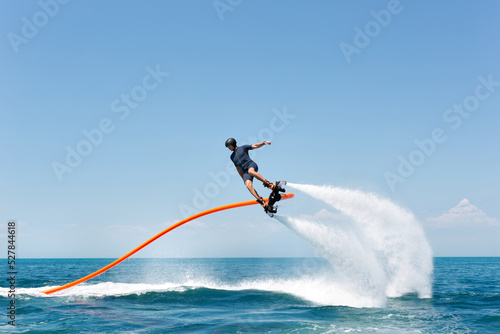 Water extreme sport. The guy is flying at the aquatic flyboard. A lot of water pressure photo