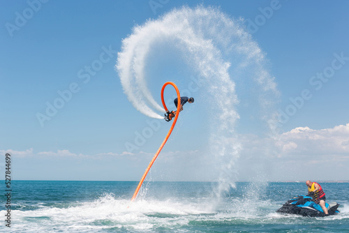 Water extreme sport. A man flies on a water flyboard photo