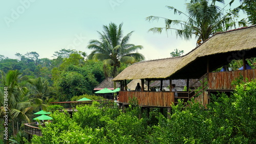 traditionelles Restaurant aus Holz auf Stelzen über dem Dschungel von Bali gebaut unter blauem Himmel