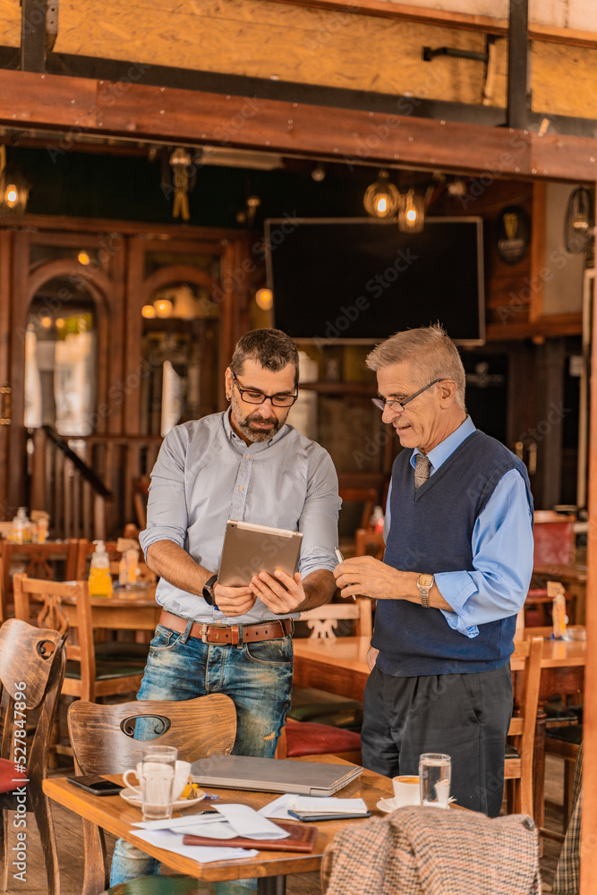Looking at some informations on the tablet while standing in the cafe Looking at some informations on the tablet while standing in the cafe