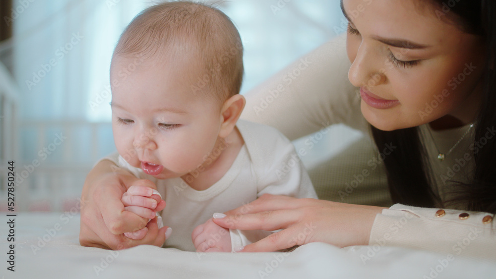 In front of the camera beautiful and charismatic woman hugging with love her baby girl and closing the eyes she enjoy the motherhood In front of the camera beautiful and charismatic woman hugging with love her baby girl and closing the eyes she enjoy the motherhood