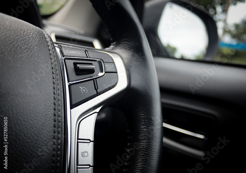 A modern feature in the car is the adaptive cruise control button on the steering wheel. Change of speed, close-up