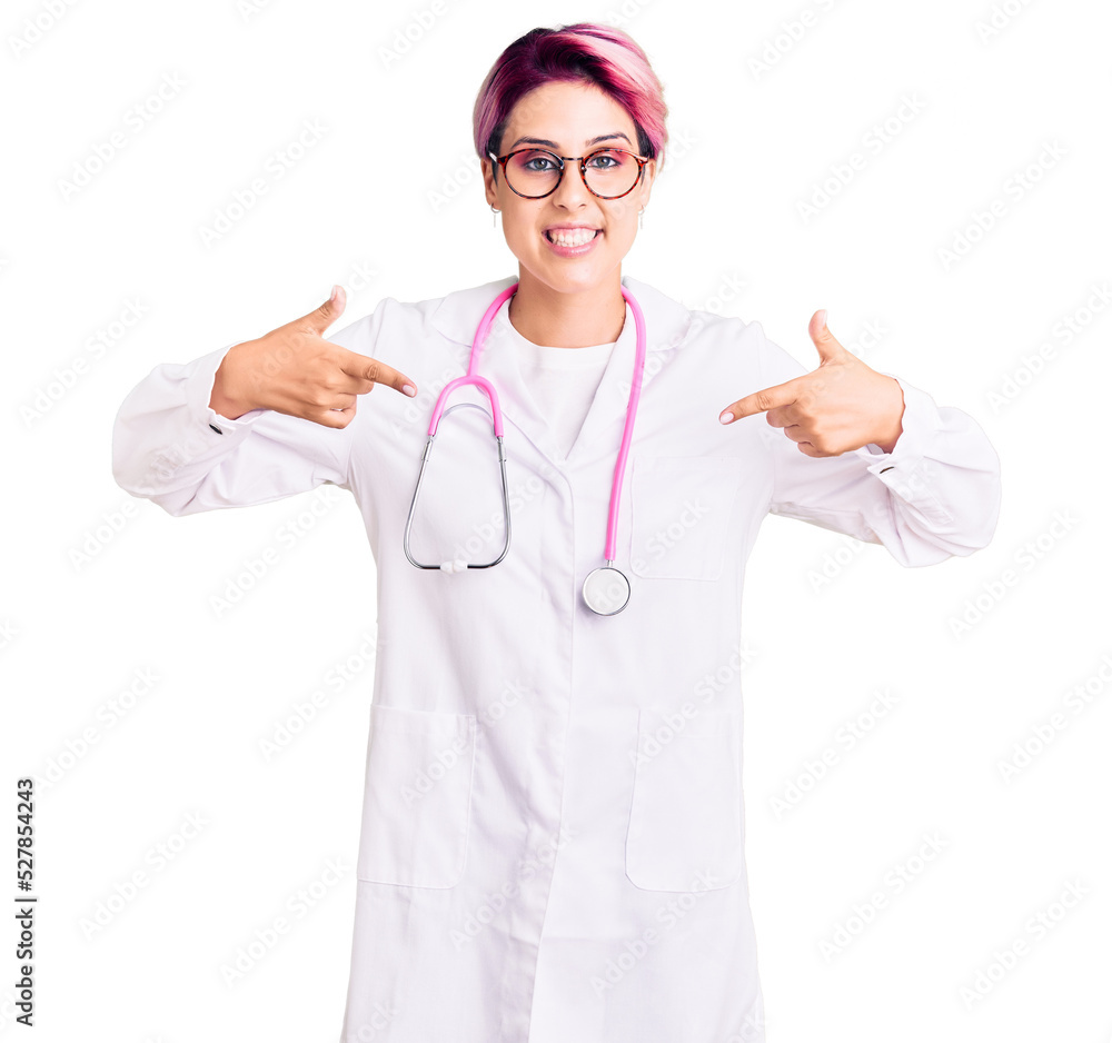 Young beautiful woman with pink hair wearing doctor uniform looking confident with smile on face, pointing oneself with fingers proud and happy. Young beautiful woman with pink hair wearing doctor uniform looking confident with smile on face, pointing oneself with fingers proud and happy.