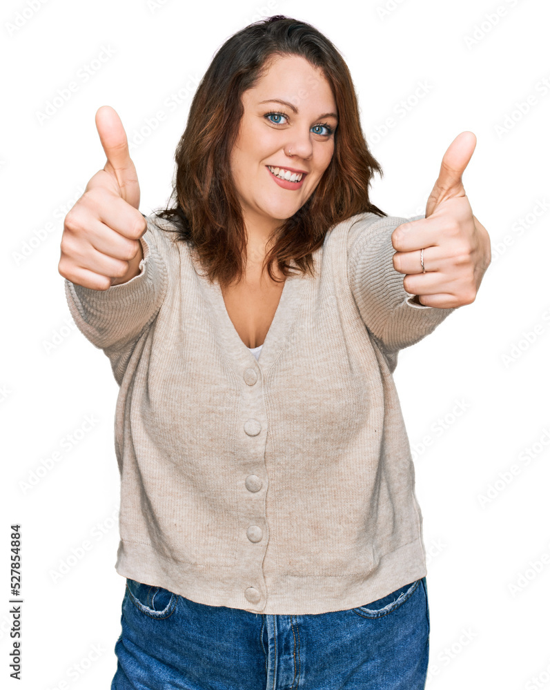 Young plus size woman wearing casual clothes approving doing positive gesture with hand, thumbs up smiling and happy for success. winner gesture. Young plus size woman wearing casual clothes approving doing positive gesture with hand, thumbs up smiling and happy for success. winner gesture.