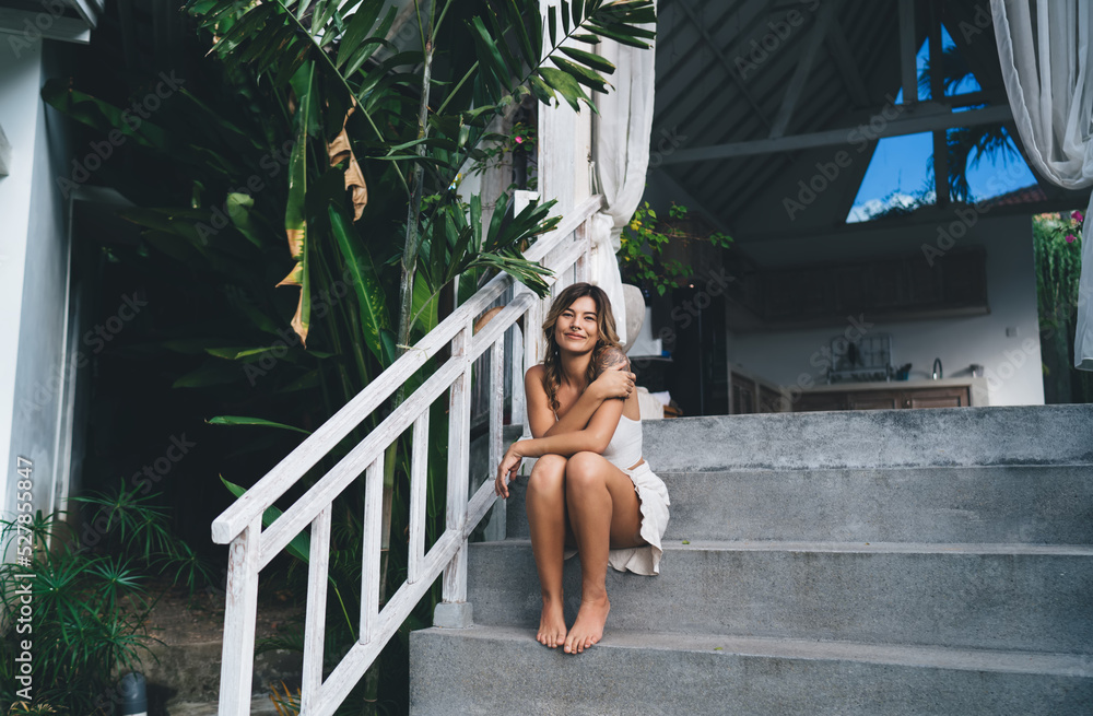 Young woman resting on stairs of resort hotel