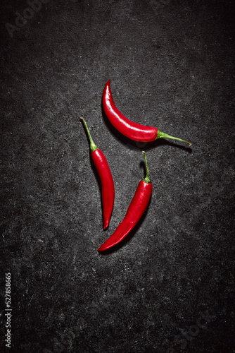 Group of red hot spicy vegetables. High angle view of chilli peppers on dark blue background. Spicy ingredients in kitchen