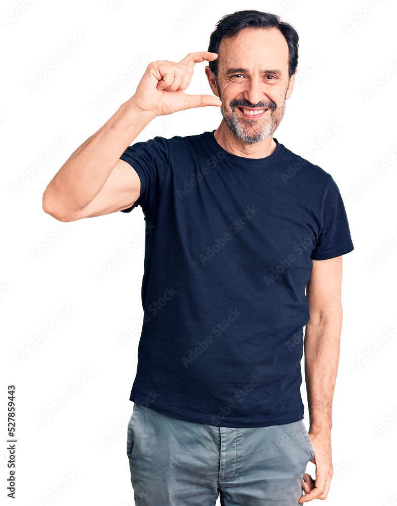 Middle age handsome man wearing casual t-shirt smiling and confident gesturing with hand doing small size sign with fingers looking and the camera. measure concept. Middle age handsome man wearing casual t-shirt smiling and confident gesturing with hand doing small size sign with fingers looking and the camera. measure concept.