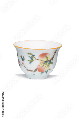 Detailed shot of a white original porcelain color printed cup in chinese style. The designer bowl with an image of a fruit branch is isolated on the white background.