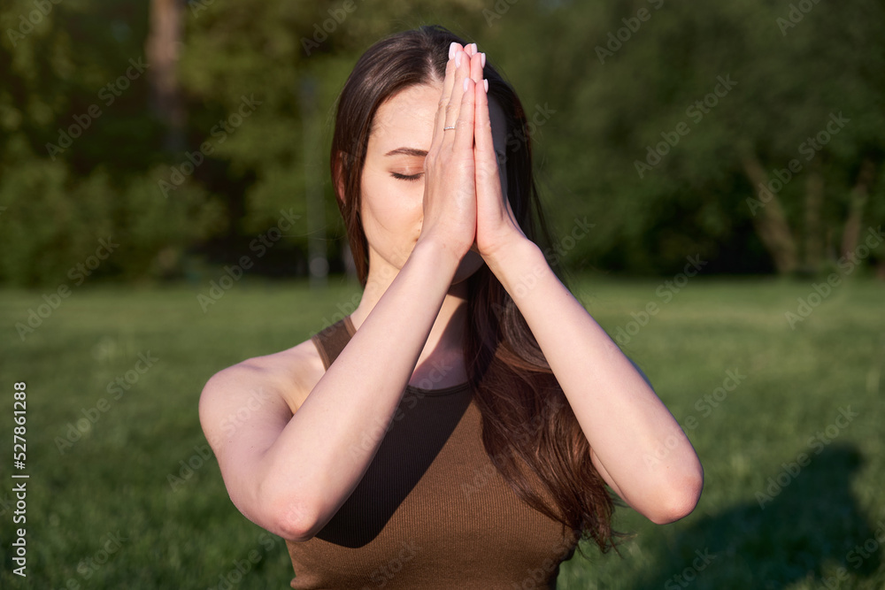 Young athletic woman doing yoga or outdoor sports in the park, rear view.