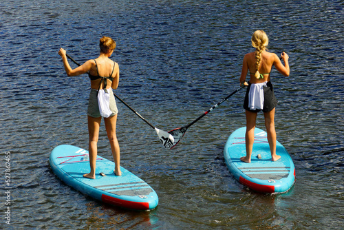 Zwei junge Frauen beim stand-up-paddling  photo