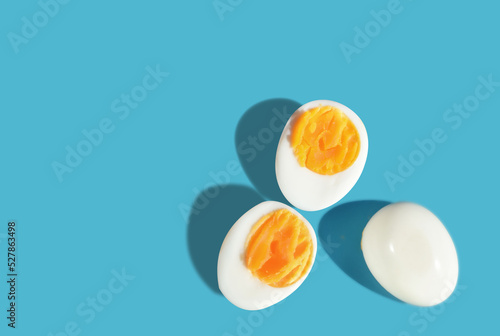 Boiled eggs slice with shadow on blue background with sunlight. Copy space concept and torether idea