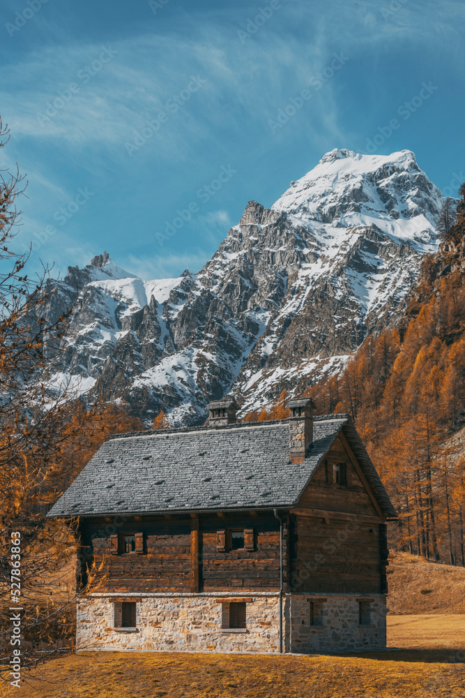 mountain house in front of a landscape of a village view in the mountains at autumn on a sunny day