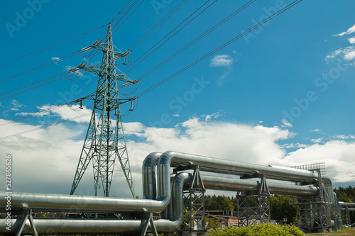 pipeline and power line support, in the photo pipeline and power line tower close-up against the background of blue sky and clouds