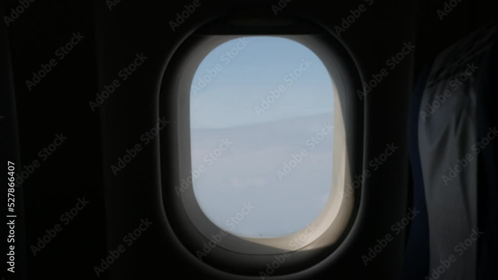 View from in side plane cabin through plane window while flying above sky View from in side plane cabin through plane window while flying above sky