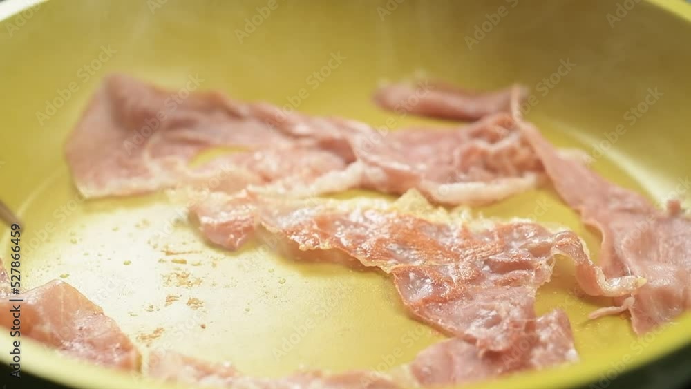 The cook turns the prosciutto crudo in the frying pan.
The cook turns the prosciutto crudo in the frying pan.
