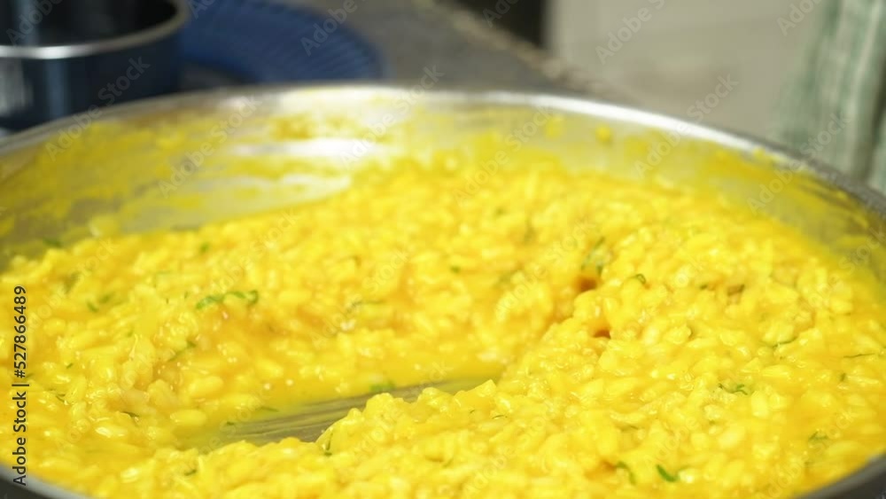 The cook takes the pumpkin risotto from the pan with a spoon.
The cook takes the pumpkin risotto from the pan with a spoon.