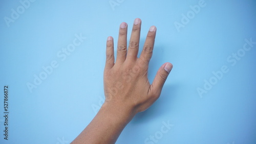 Hand extended in greeting isolated on blue background. Number five. © MdzFahmi
