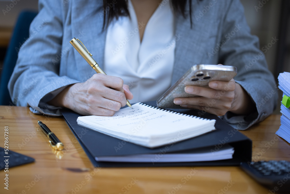 Close up of businesswoman hands using smart phone at workplace in office. Close up of businesswoman hands using smart phone at workplace in office.