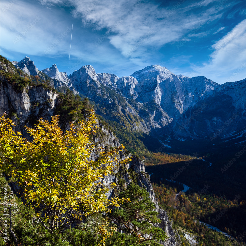 Sunny colorful autumn alpine scene. Peaceful rocky mountain view from hiking path near Almsee lake, Upper Austria.