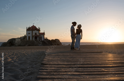 Couple embracing on sea beach during honeymoon at sunset photo
