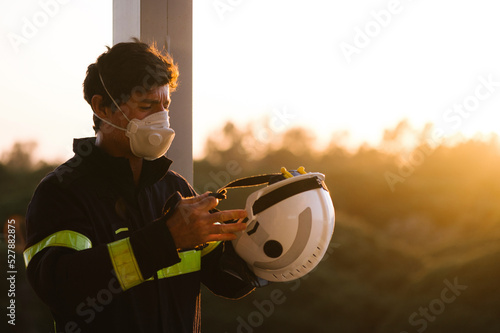 Firefighter getting dressed to start work disinfecting a buildin photo