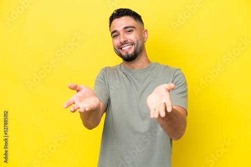 Young Arab handsome man isolated on yellow background happy and smiling